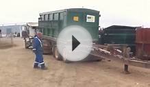 Waste Management roll off truck loading a pup trailer.